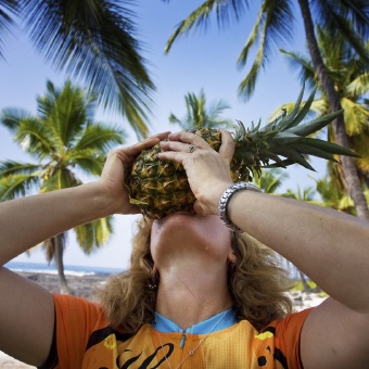 Cyclist eating a pineapple Hawaii Bike Tour