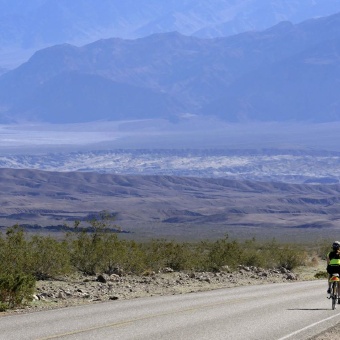 Cyclist biking in the desert Death Valley Bike Tour