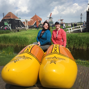 WomanTours pose four a photo with giant wooden clogs Holland Bike and Barge Meandering the Meuse Bike Tour