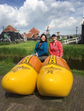 WomanTours pose four a photo with giant wooden clogs Holland Bike and Barge Meandering the Meuse Bike Tour