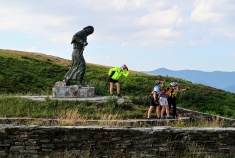 Cyclist posing with a statue Spain Camino de Santiago bike tour