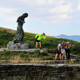Cyclist posing with a statue Spain Camino de Santiago bike tour