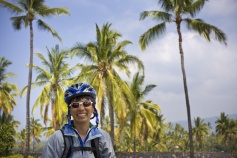 Cyclist posing for camera with coconut trees  Hawaii Bike Tour
