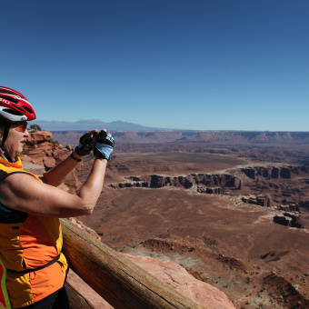 Cyclist taking a picture of scenery during Moab Arches and Canyonlands Bike Tour