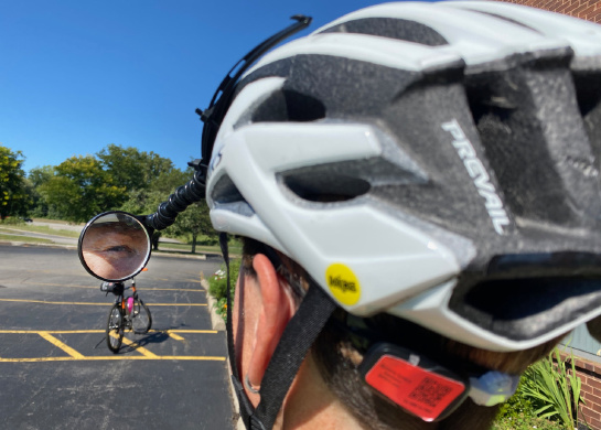Jackie demonstrates using a bike helmet mirror, which helps her monitor the traffic behind her. 