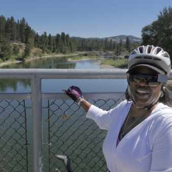 Cyclist posing for photon on bridge Idaho Greenways Bike Tour