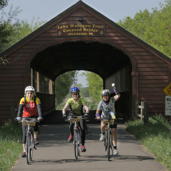 Cyclist under scenic bridge Minnesota Lake Wobegon Trail Bike Tour