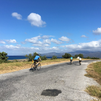 three bicyclists on road on Cuba bike tour