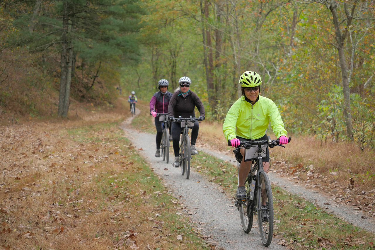 women bike riding on a gravel path