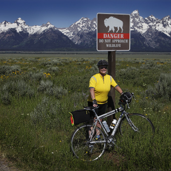 Cyclist posing for a photo by a buffalo sign Idaho Teton Valley Bike Tour