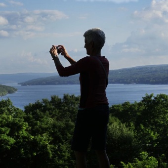 WomanTours guest taking a photo on the view Finger Lakes Bike Tour