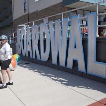 Cyclist pose for photo on boardwalk Jersey Shore Bike Tour