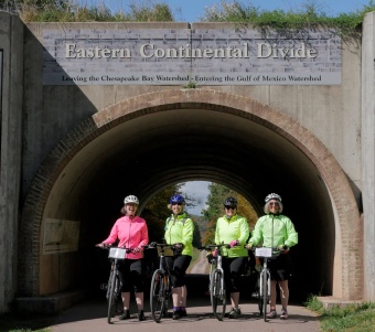 Four WomanTours cyclists celebrate their climb to the Great Continental Divide on the Great Allegheny Passage.