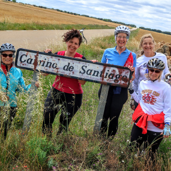 Cyclist holding up sign and posing for camera Spain Camino de Santiago bike tour