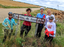 Cyclist holding up sign and posing for camera Spain Camino de Santiago bike tour