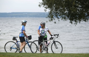 Cyclist resting by lake shore Finger Lakes Bike Tour
