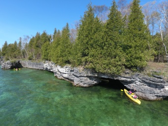 Exploring a cave while kayaking on our Wisconsin Door County bike tour.