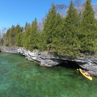 Exploring a cave while kayaking on our Wisconsin Door County bike tour.