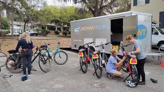 WomanTours guide Mel (in purple) adjusts a bike for a rider on the Florida: Forgotten Coast tour.